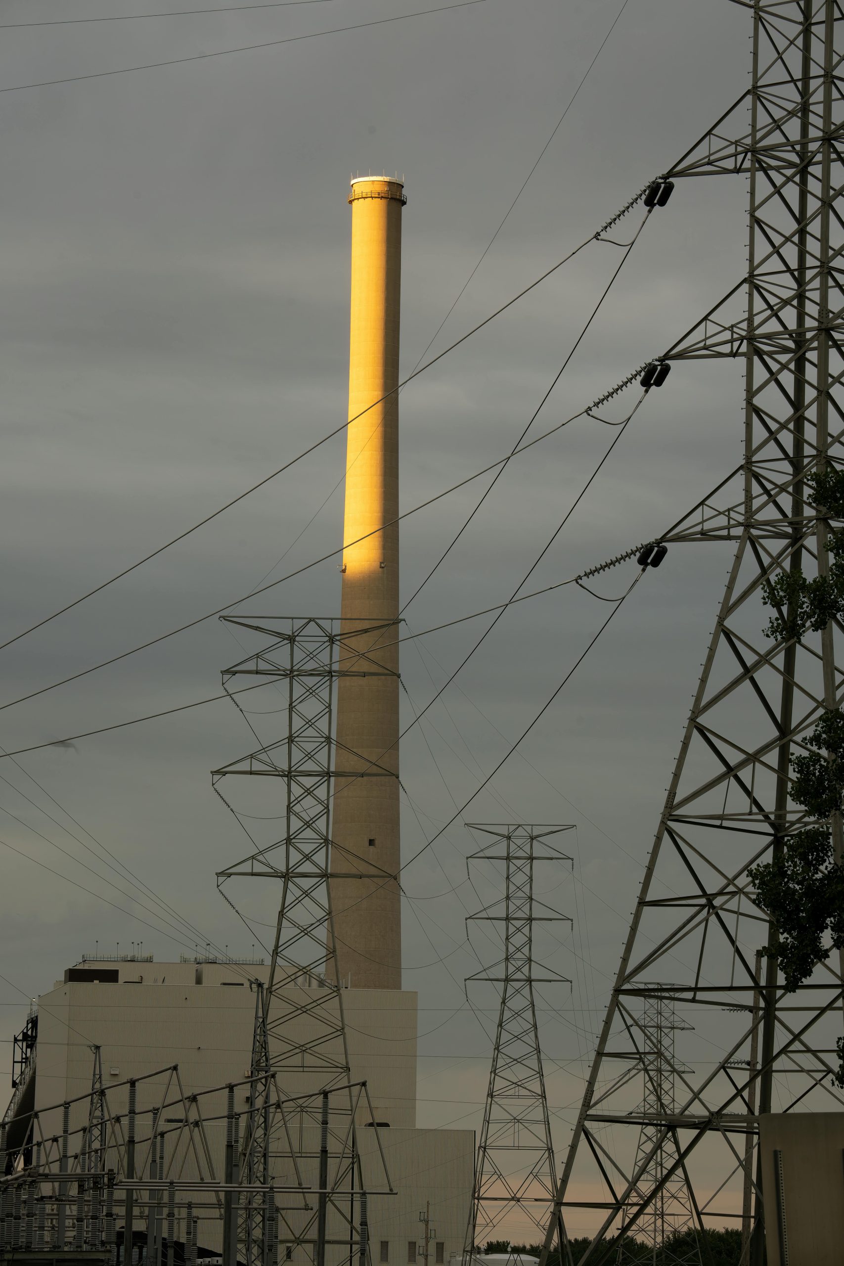 A power plant in Alma, WI with smokestack and pylons at dusk, illustrating industrial energy.